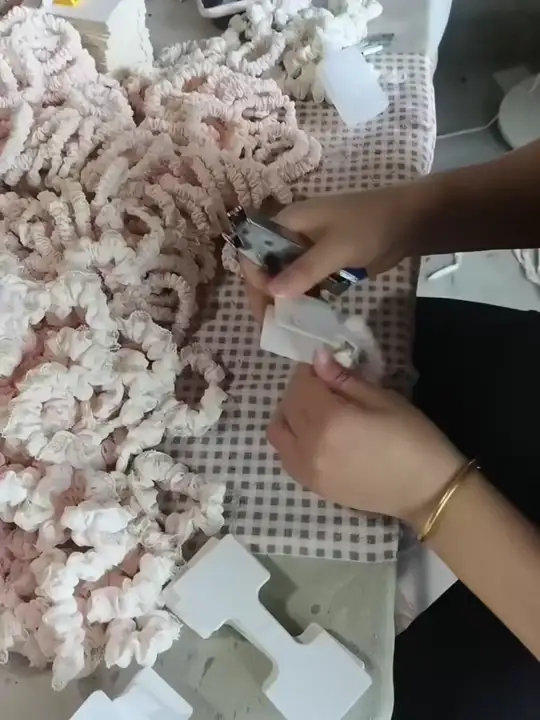 Mãos organizando pequenos acessórios e cartões sobre uma mesa.