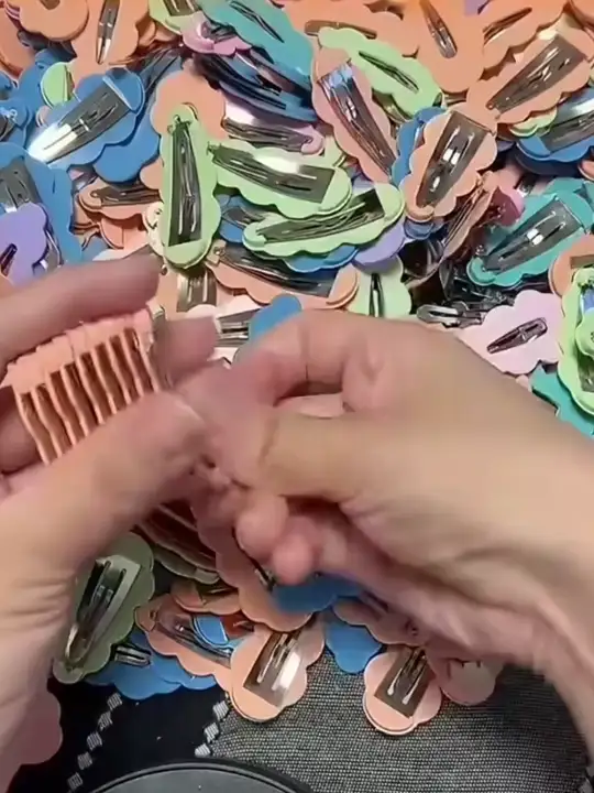 Mãos organizando acessórios de tecido e embalagens.